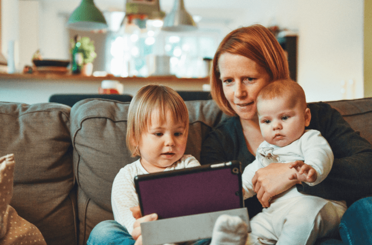 Bebeklerle birlikte tablet bilgisayara bakan kadın